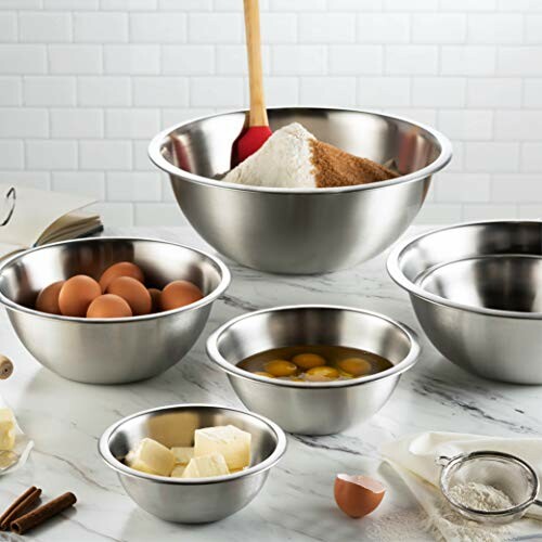 Stainless steel bowls with baking ingredients on a counter.