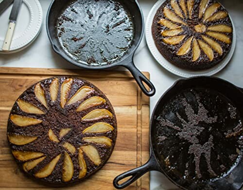Chocolate pear upside-down cakes in cast iron skillets and a cutting board.