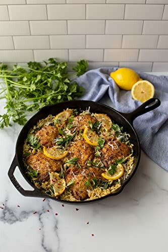 Lemon chicken with herbs and rice in a skillet.