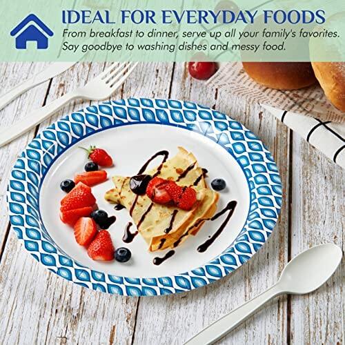 Paper plate with crepes, strawberries, blueberries, and chocolate drizzle.